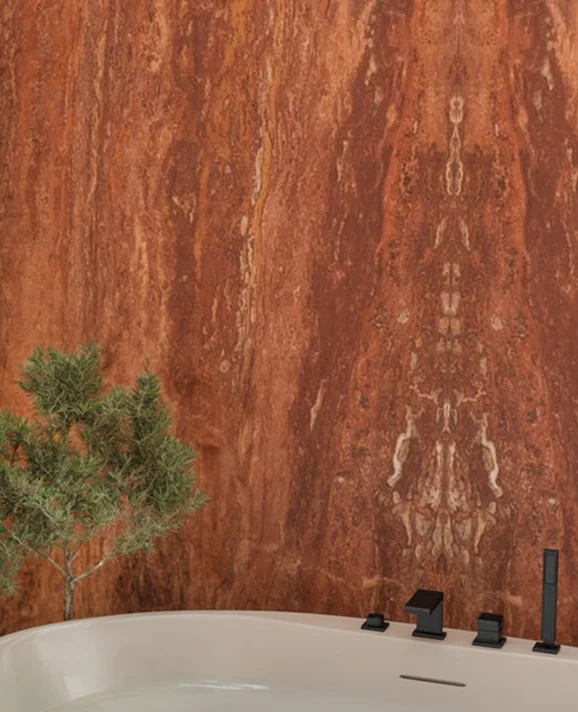 Bathtub against a full-height red natural stone wall